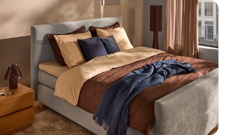 een bed met kussens en een lamp
