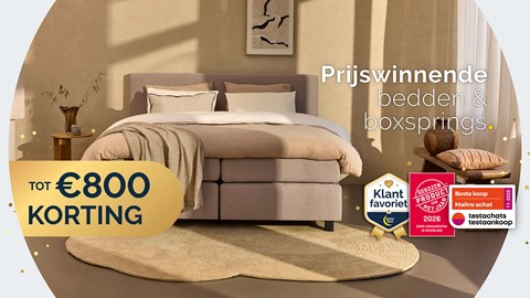 Een bed met kussens en dekens in een kamer