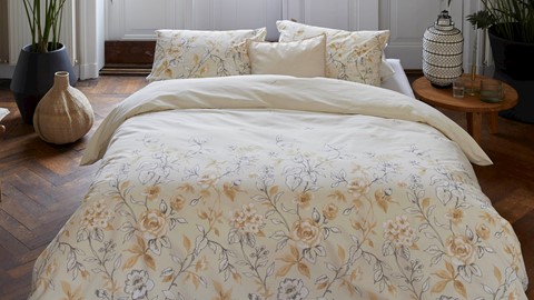 een bed met een bloemendekbed en kussens