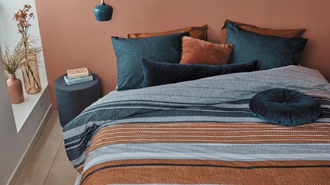 een bed met kussens en een bijzettafel