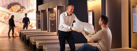 Een man die een kussen aan een vrouw geeft