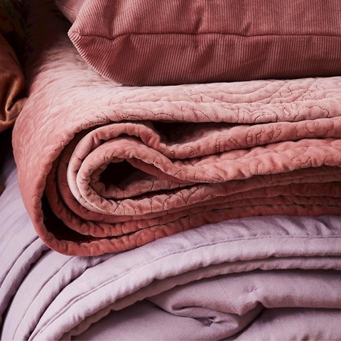 Roze spreien en plaids op een stapel