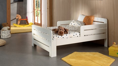 een wit houten bed met een knuffel erop
