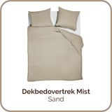 Een bed met een witte deken en kussens