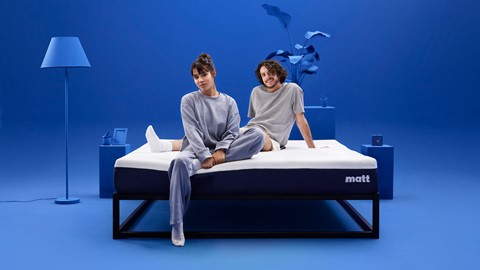 Een man en een vrouw die op een matras zitten