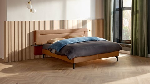 een bed met een hoofdeinde en een lamp