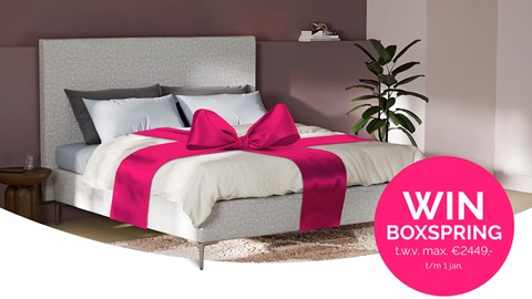 Een bed met een roze strik