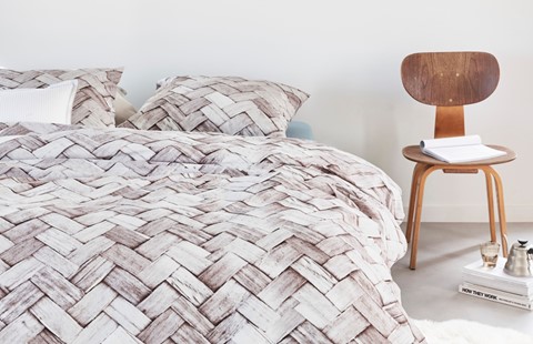 een bed met kussens en een stoel
