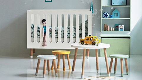 een kinderkamer met een wieg en kleine tafels