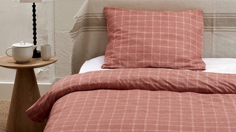 een bed met een kussen en een deken