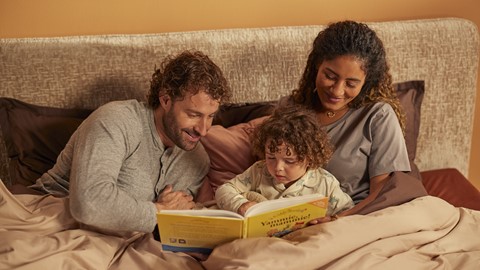 een man en een vrouw die een boek voorlezen aan een kind