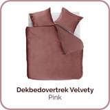 een bed met roze lakens en kussens