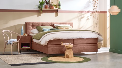 een bed met een bedframe en een kleine tafel