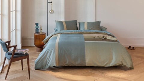 een bed met een sprei en kussens