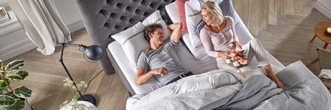 Een man en een vrouw die in een bed liggen
