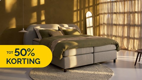 een bed in een kamer met een rond kleed en een raam