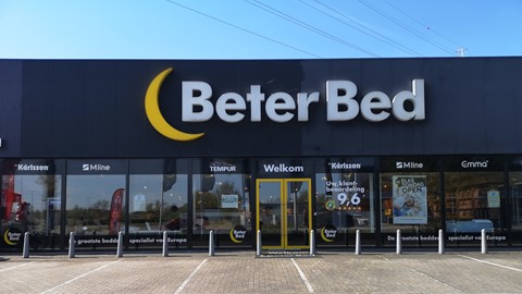 een gebouw met glazen deuren en een uithangbord