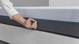 een persoon die een matras vasthoudt