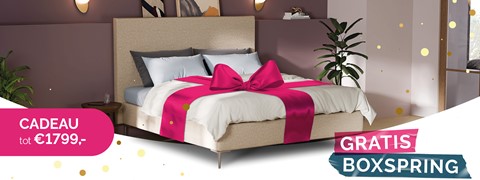 een bed met een roze strik