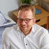 een man met een bril en een wit overhemd