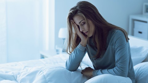 Een vrouw die op een bed zit