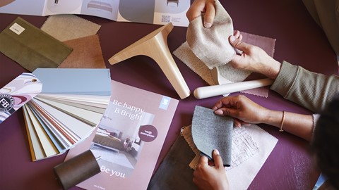 Iemands handen die stofmonsters vasthouden