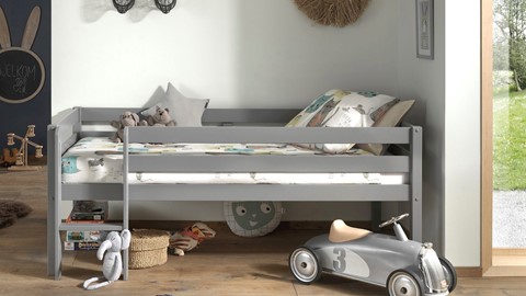Een bed met een speelgoedauto en speelgoed op de vloer