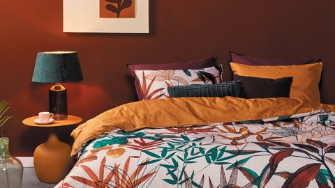 een bed met oranje en bruine kussens