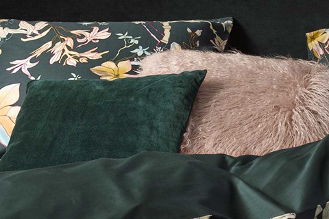Een roze kussen op een bed