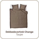 een bed met bruine lakens en kussens