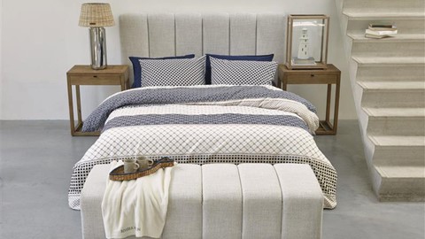 een bed met een wit en blauw beddengoed