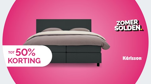 Een bed met een roze achtergrond