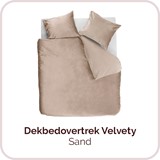 Een bed met kussens en een deken