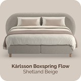Een bed met een gebogen hoofdeinde