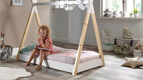 Een meisje zittend op een bed