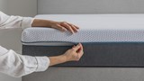 de hand van een persoon die een matras vasthoudt