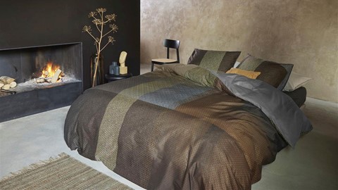 een bed met een deken en kussens