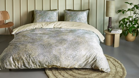 Een bed met beddengoed en kussens