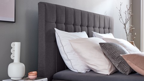 een bed met kussens en een bijzettafel