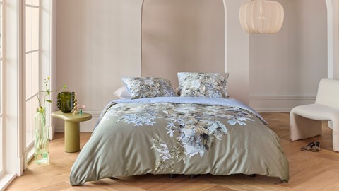 een bed met een bloemendekbed en kussens