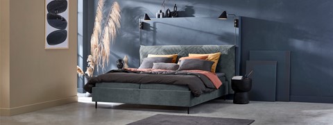 een bed met kussens en een lamp