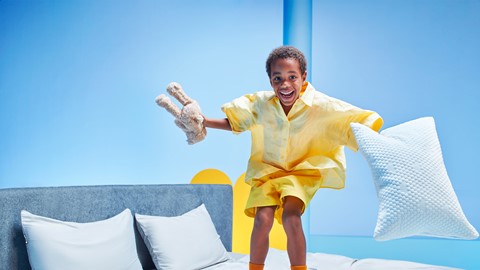 Een jongen die op een bed springt