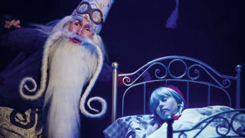 Een man in een kledingstuk naast een kind in een bed