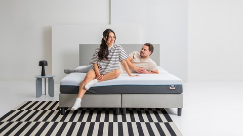 een man en een vrouw zittend op een bed