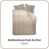 een bed met een wit dekbed en bruine kussens