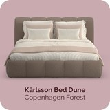 een bed met kussens en een roze achtergrond