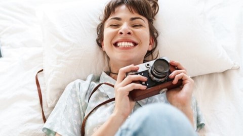 Een vrouw die ligt met een camera