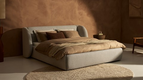 een bed met kussens en een tapijt in een kamer