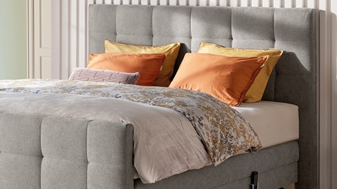 een bed met oranje kussens