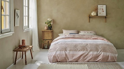 een slaapkamer met een bed en een bankje